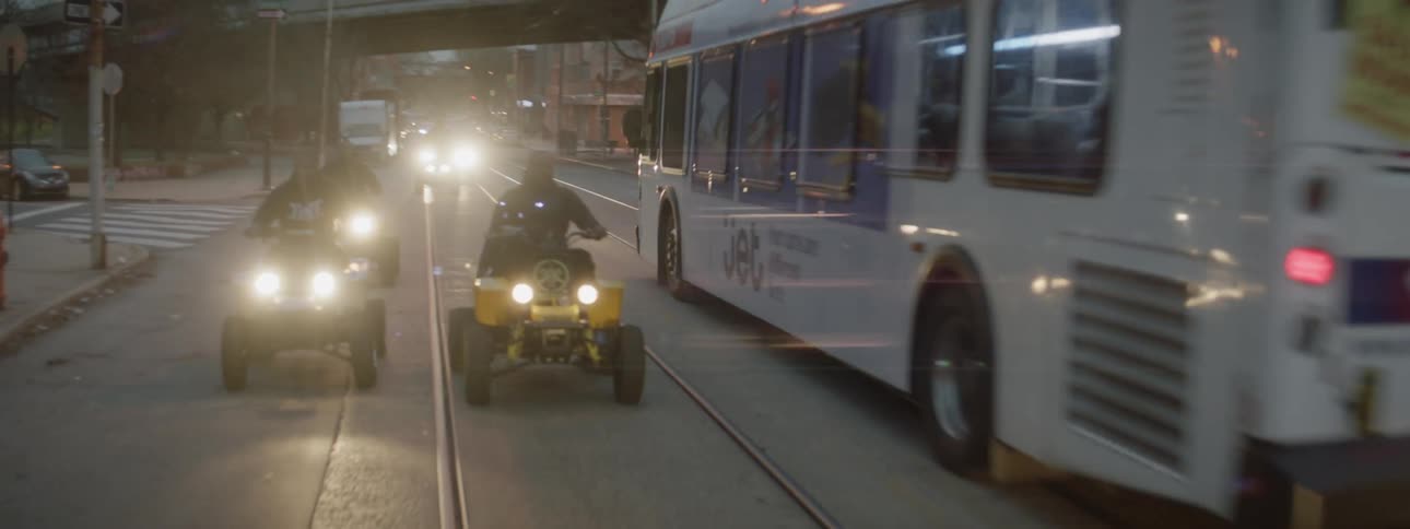 Four wheelers are driven on a city street