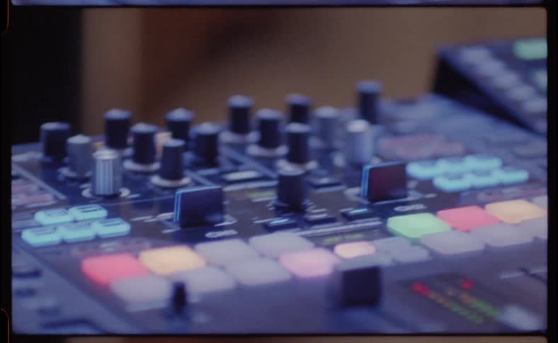 A dj is performing using a turntable and audio mixing equipment