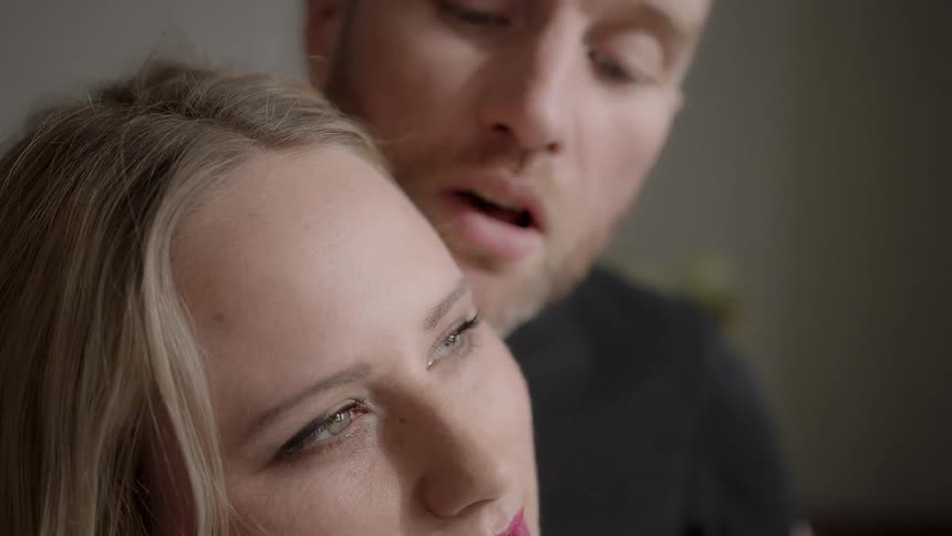 A man leans over to a woman's face
