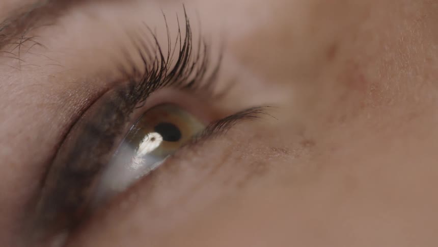 A woman with green eyes stares forward