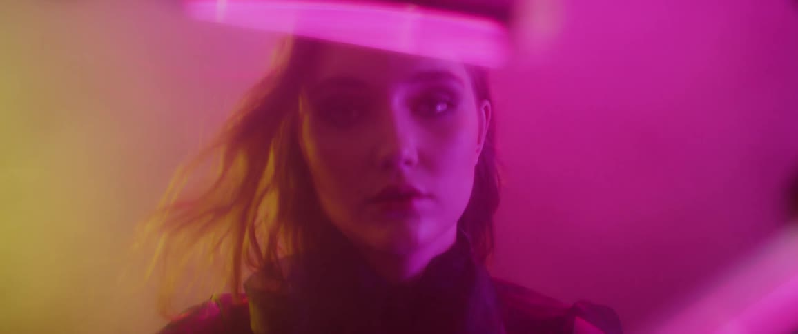 A woman looks to the side in a foggy room