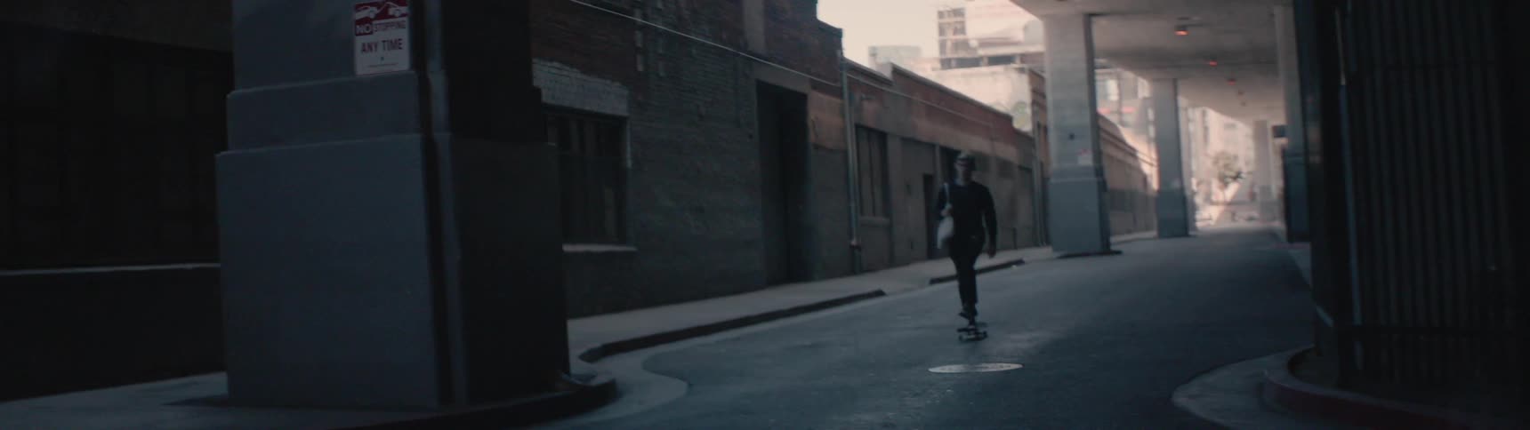 A skateboarder rides on a city street