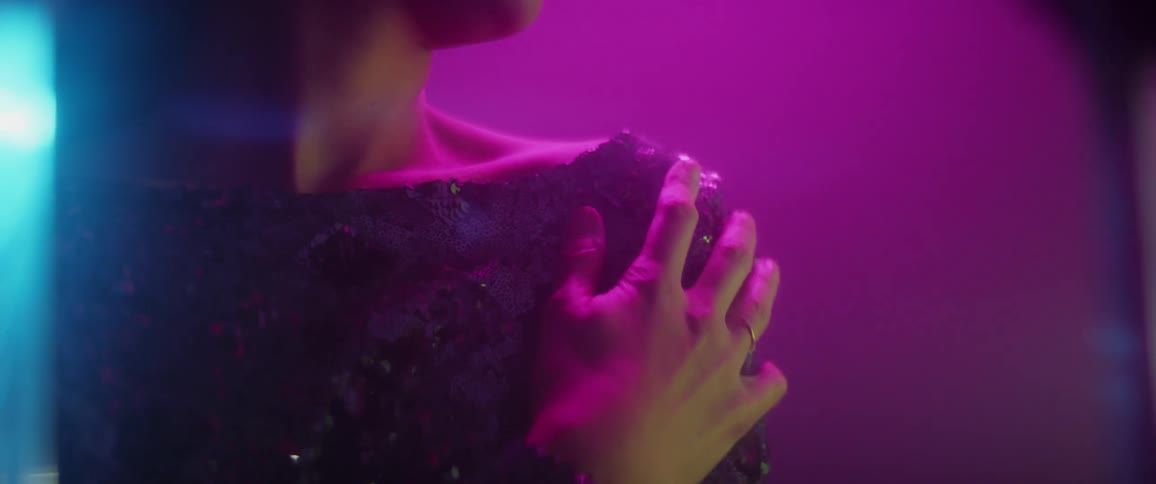 A woman rubs her hand down her shoulder and arm