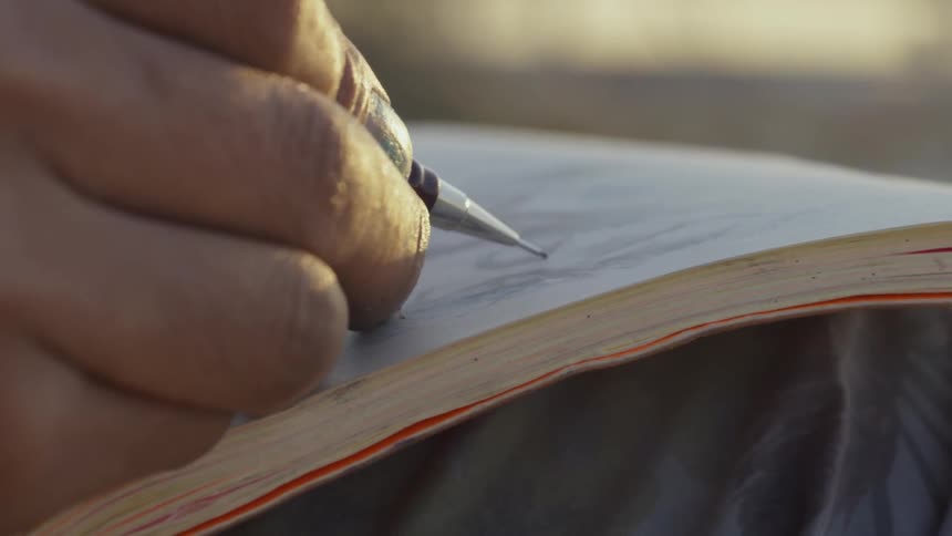 A man draws in a sketchbook