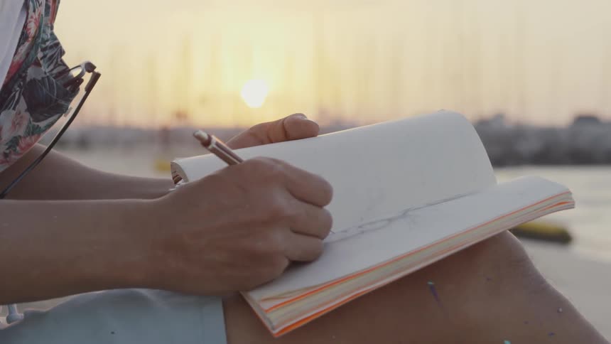 A person is drawing in their notebook