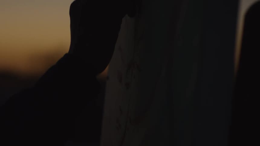 Someone is painting on canvas at sunset