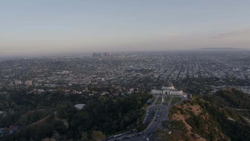 The city below has a large building on a hill beside it