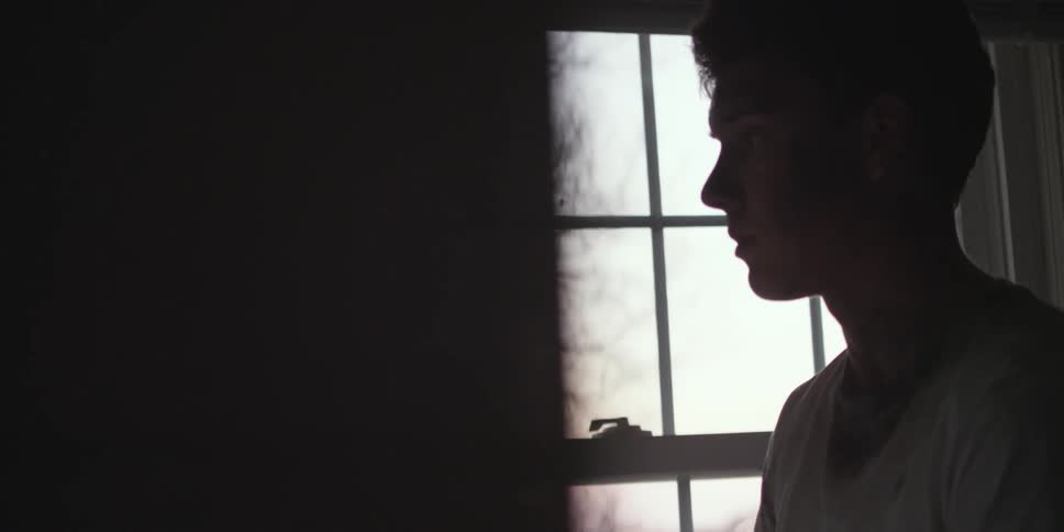 A person standing in front of a window