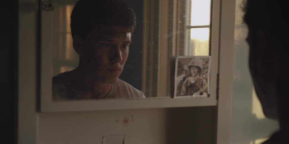 A boy looks in the mirror