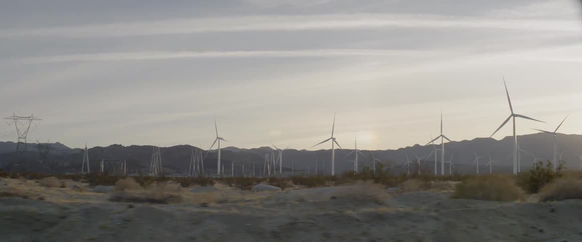 Wind turbines stand in a rural field