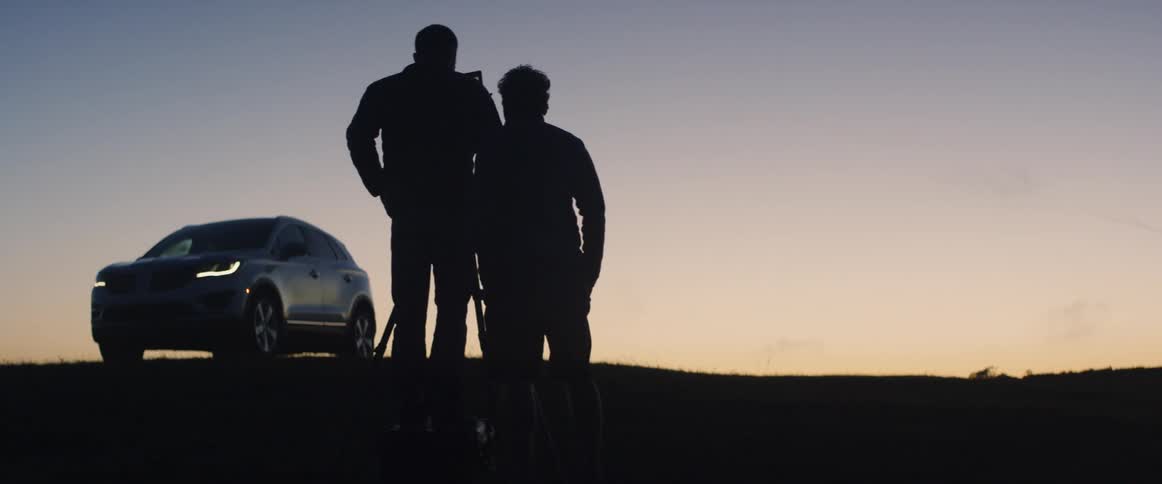 A photographer takes a photo outside at dusk