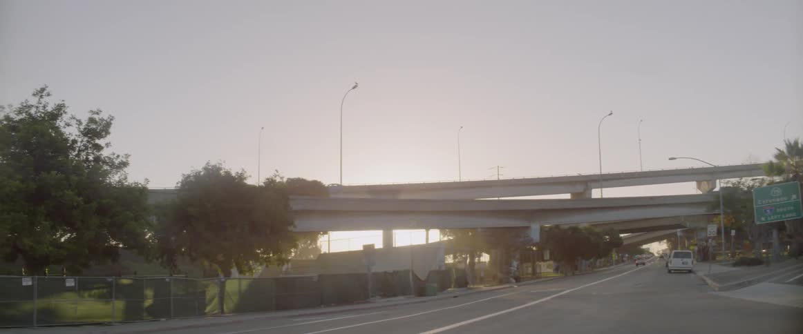 A cyclist rides on a city street at sunset