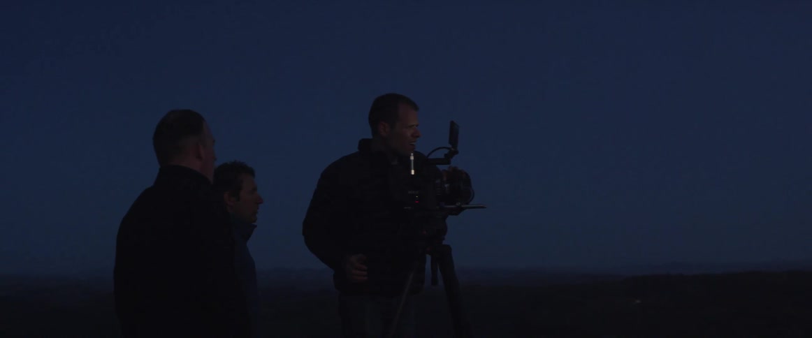 A photographer takes a photo in a rural area at night