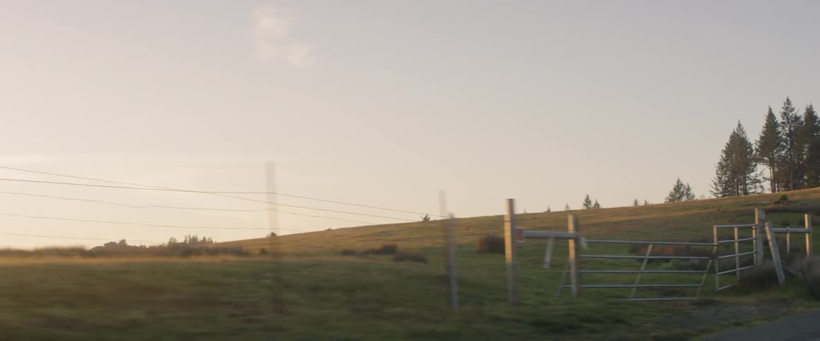 The hill is near a long wire fence