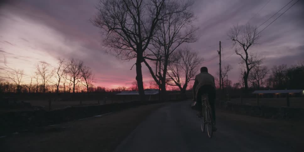 A man riding his bike at dusk