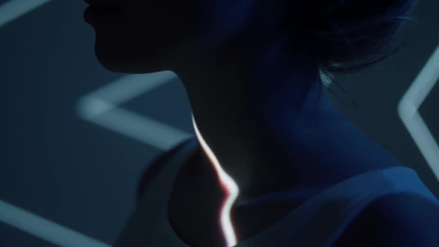 Lights shine on a woman's chest and face