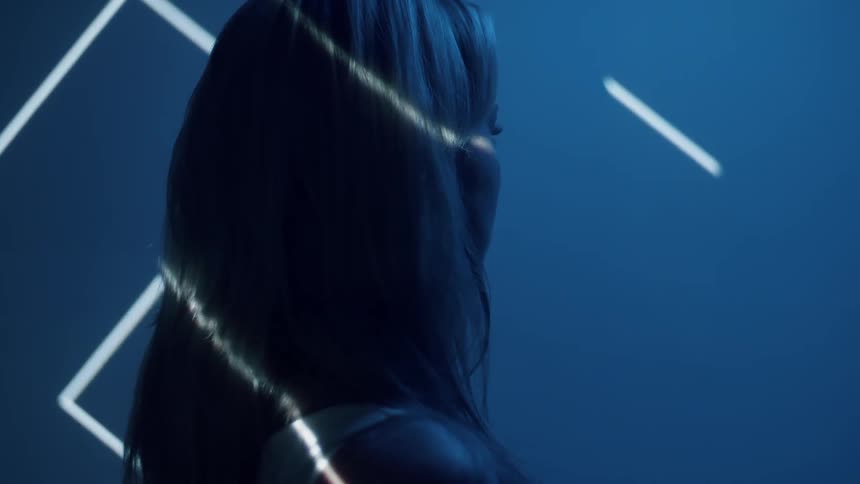 Lights shine on a woman in a dark room