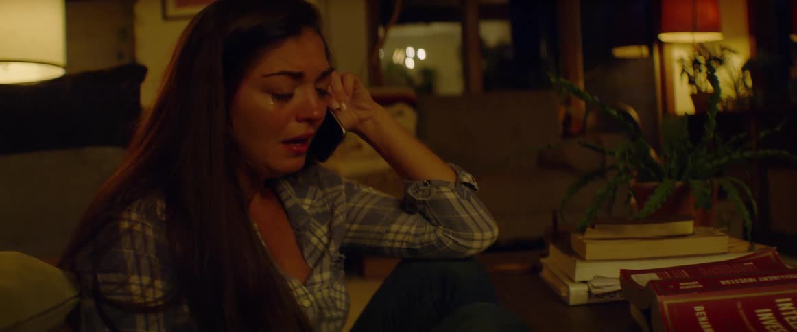 A woman cries while talking on the phone