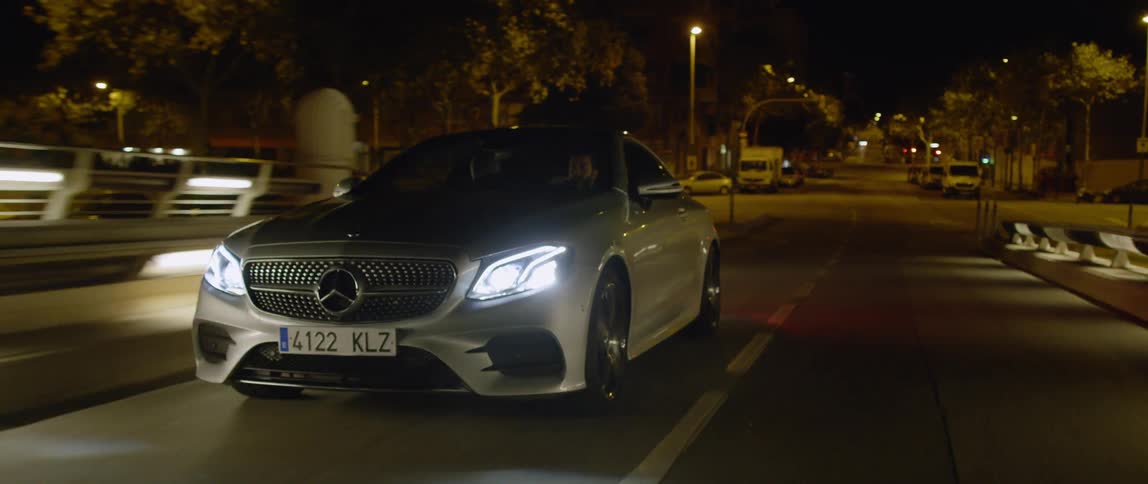 A car drives on a city street at night
