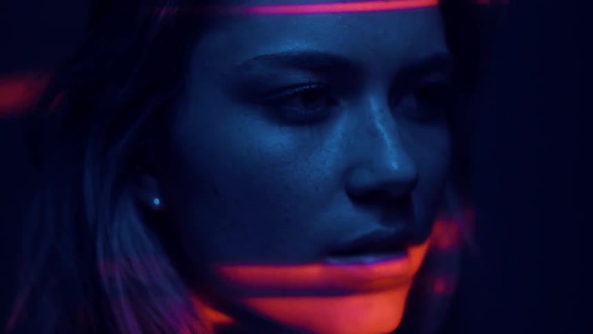 Woman's face illuminated by blue and red light