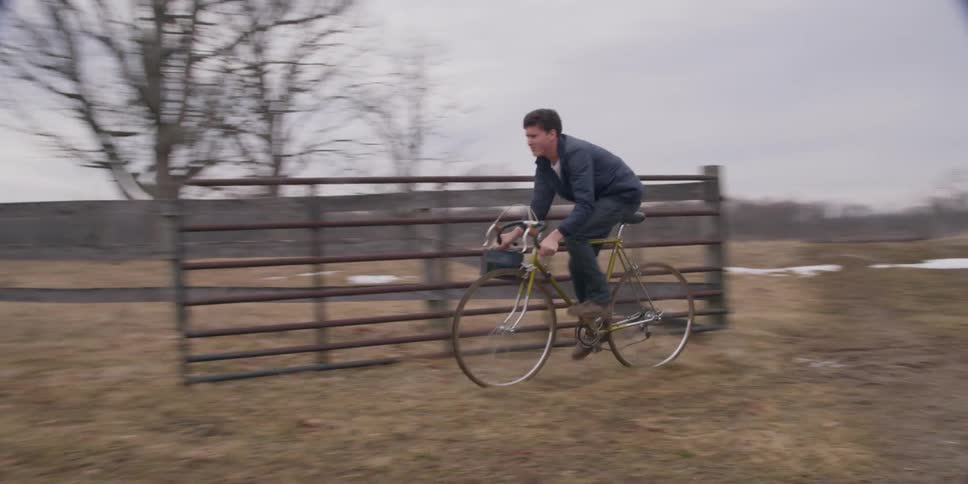 A farm i s shown with a boy riding over it