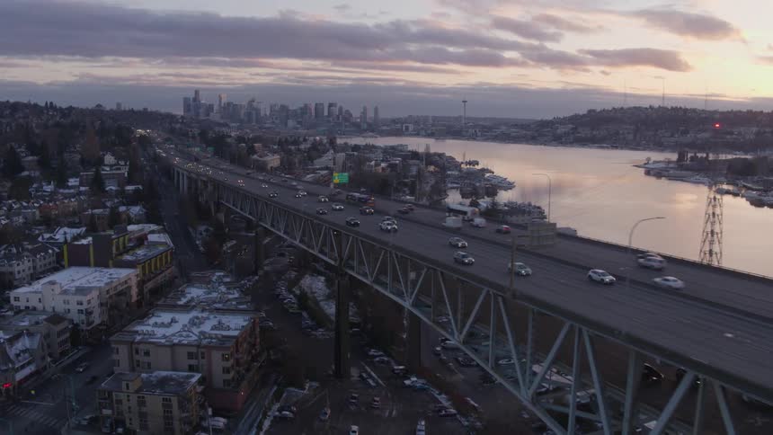 Flying alongside the top deck of the Ship Canal Bridge in Seattle as the sky reflects in Lake Union below