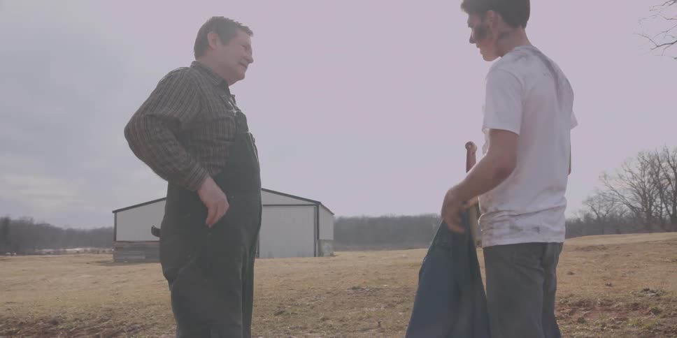 A man is standing in a field with his father
