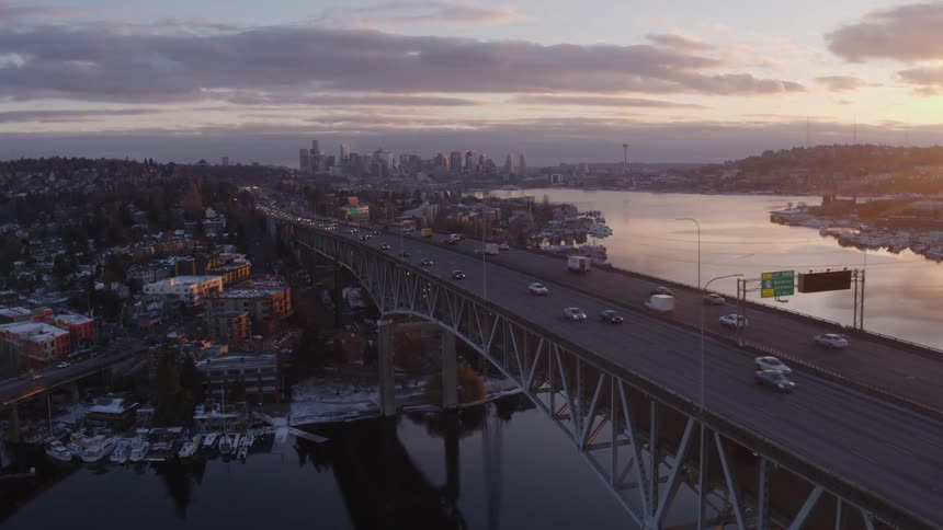 Flying over Portage Bay as traffic flows along the Ship Canal Bridge at dusk