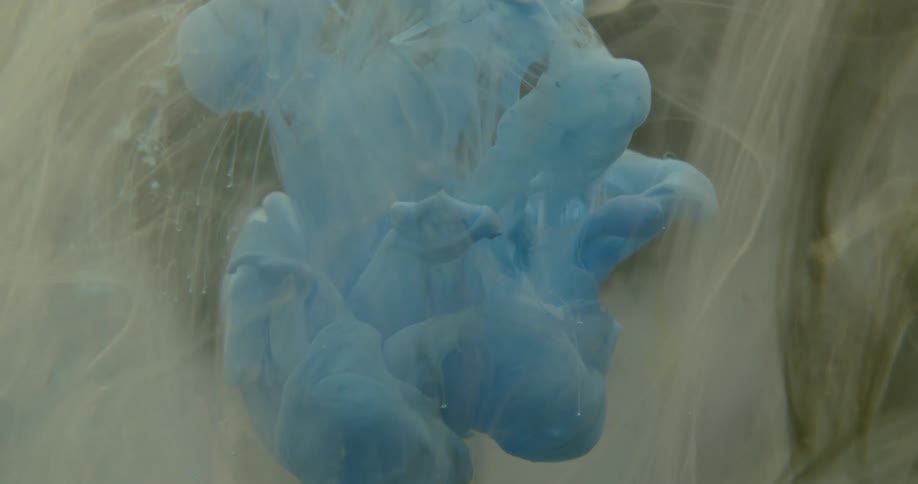 Blue and white ink creates clouds in the water