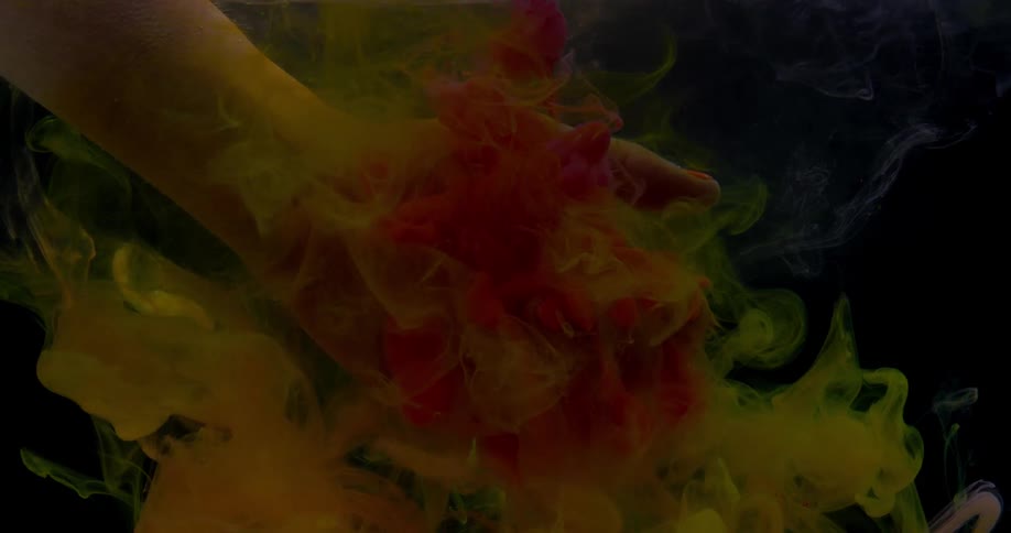 Dye flows around a woman's hand underwater