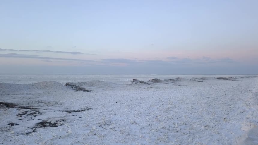 A frozen lake is covered in snow
