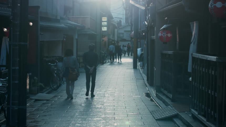Pedestrians walk on a city sidewalk