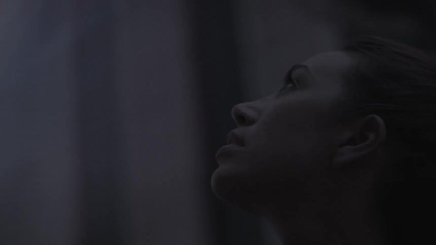 A woman is looking up as she stands outside