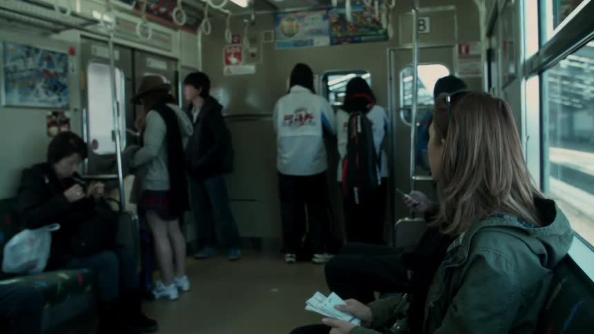 People sit and stand on a subway train