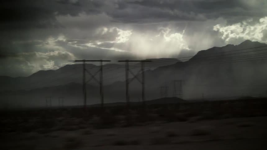 On the side of the road is a mountain covered with storm clouds