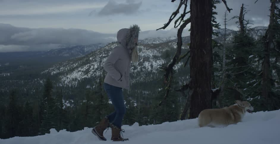 Woman walks in the snow with a dog