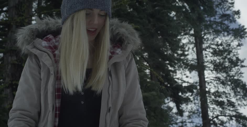 A woman feeding a dog treats on a winter day