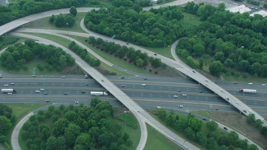 The highway has steady moving traffic on a cloudy day