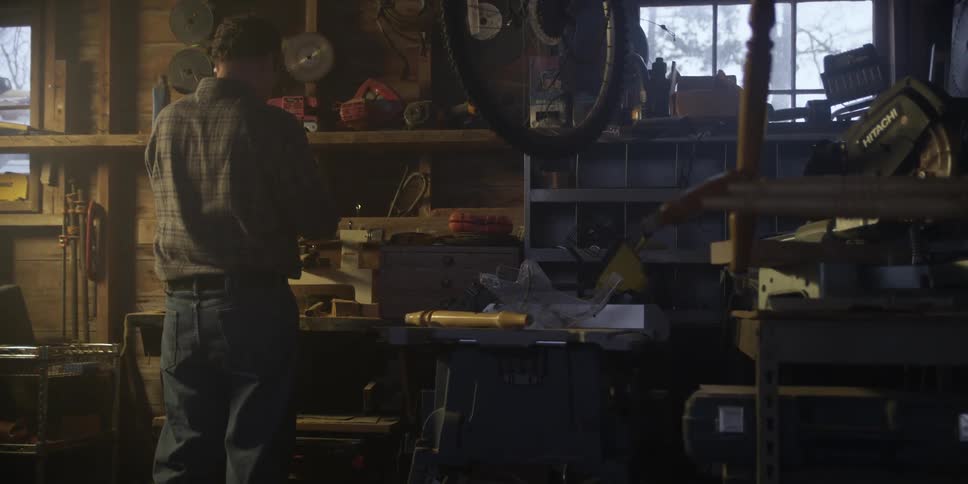 Man looking down at something in his workshop