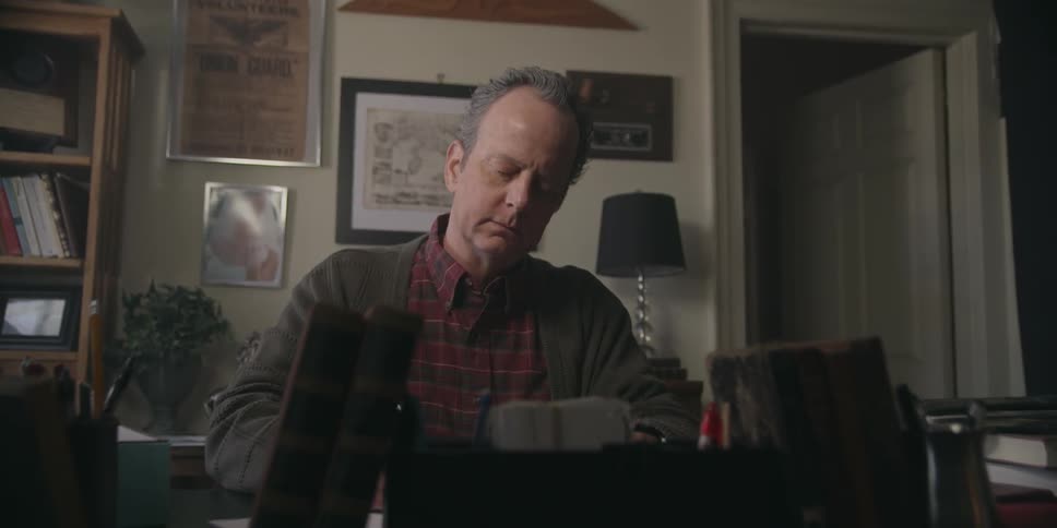 A man writes at a desk