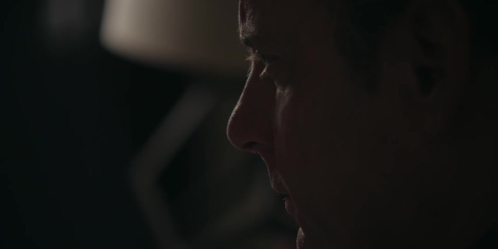 Man looks forward in a dark room