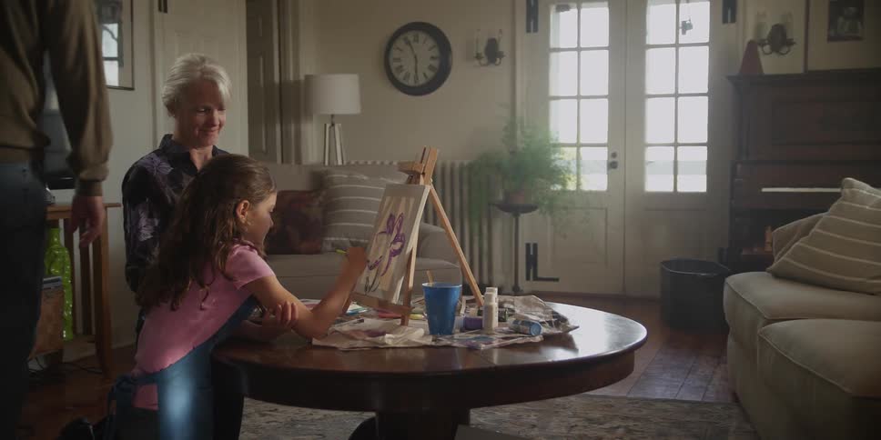 A child is drawing with their family