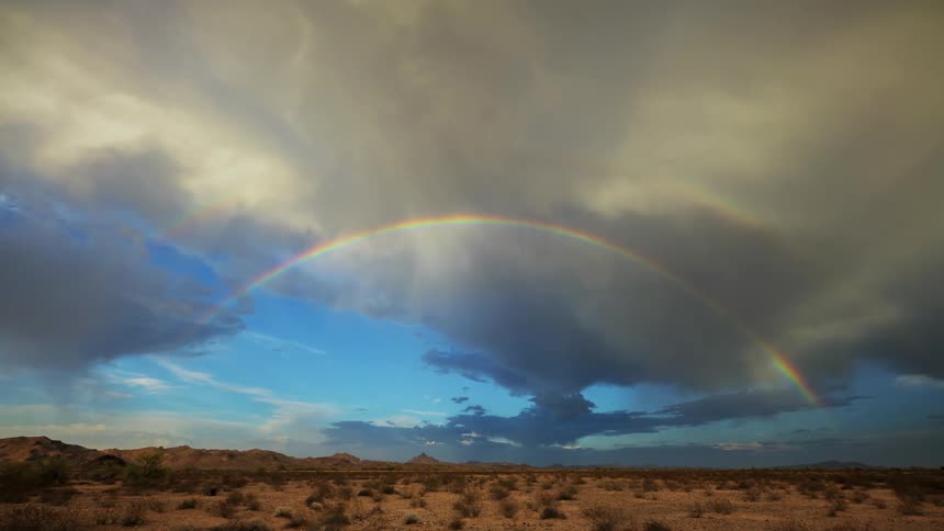 A large rainbow crosses the desert