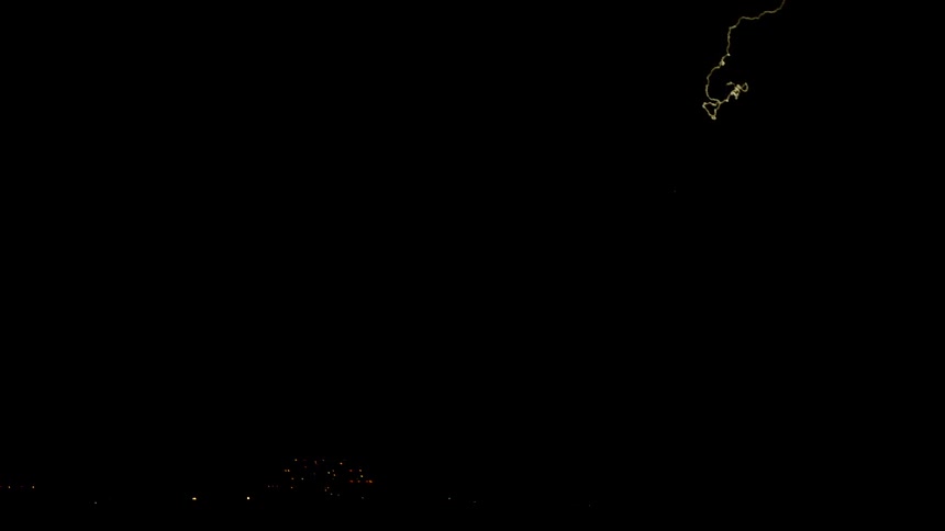 Lightning is flashing in the sky near a city at night