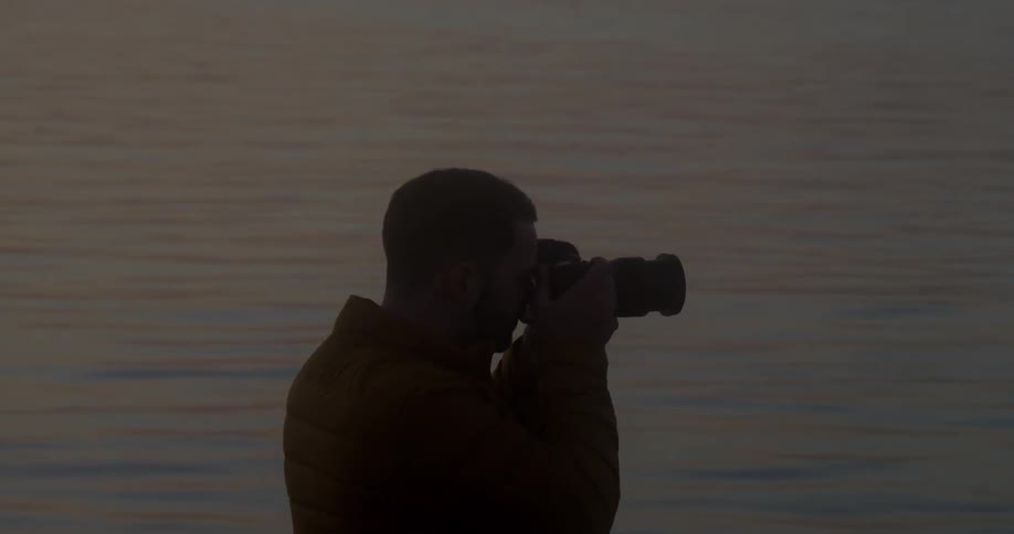 Man takes photographs near a lake