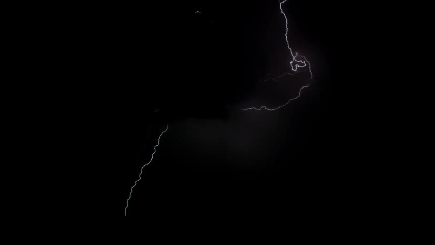 Lightning is flashing amid storm clouds above a desert landscape at night