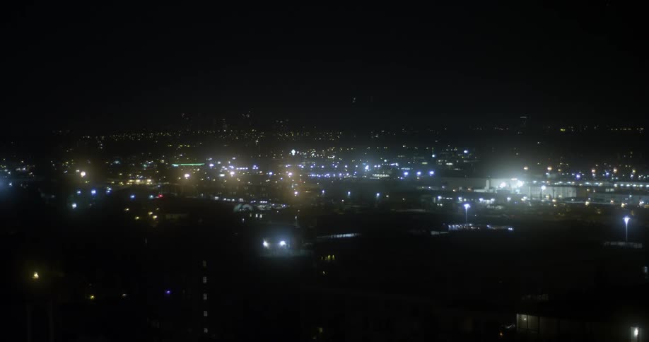 The city below is brightly lit at night