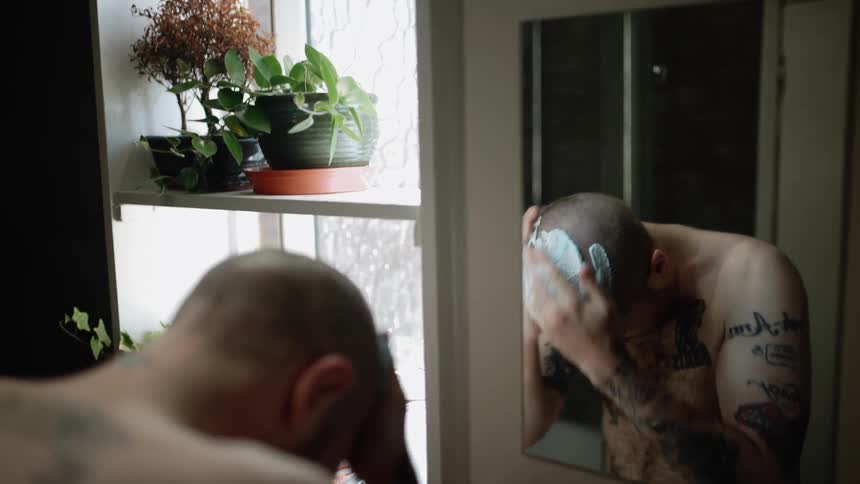 A man puts shaving cream all over his head
