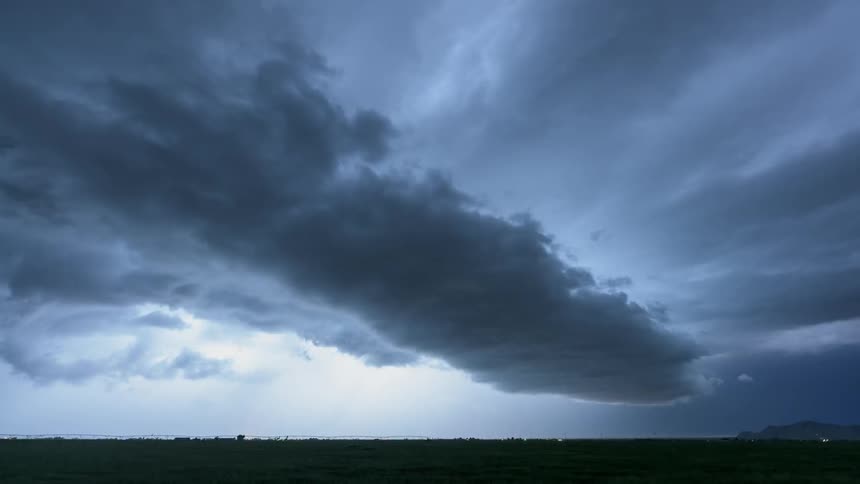Storm clouds gather and move across the sky as lightning flashes