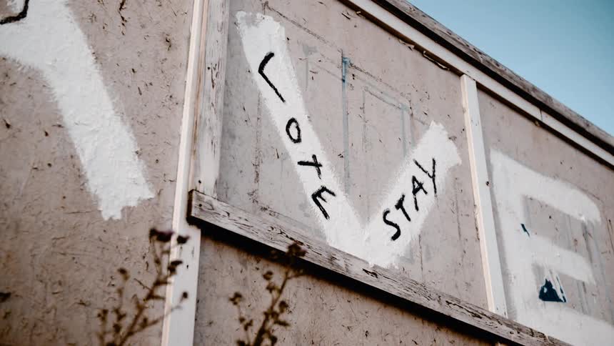 The wall is covered with graffiti on a windy day